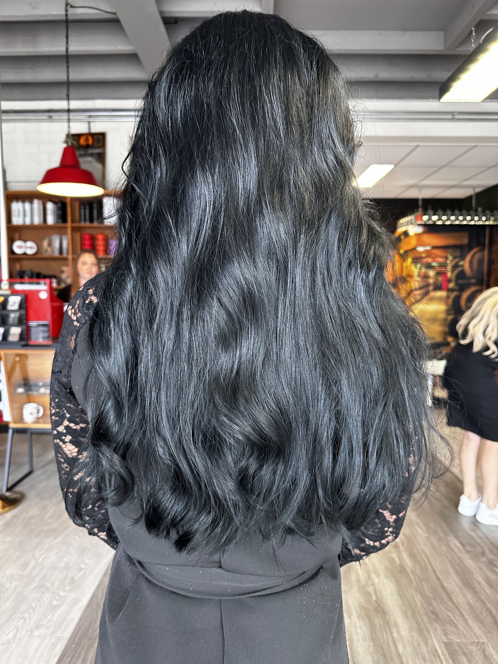 Lang zwart golvend haar, van achteren gezien in de salon