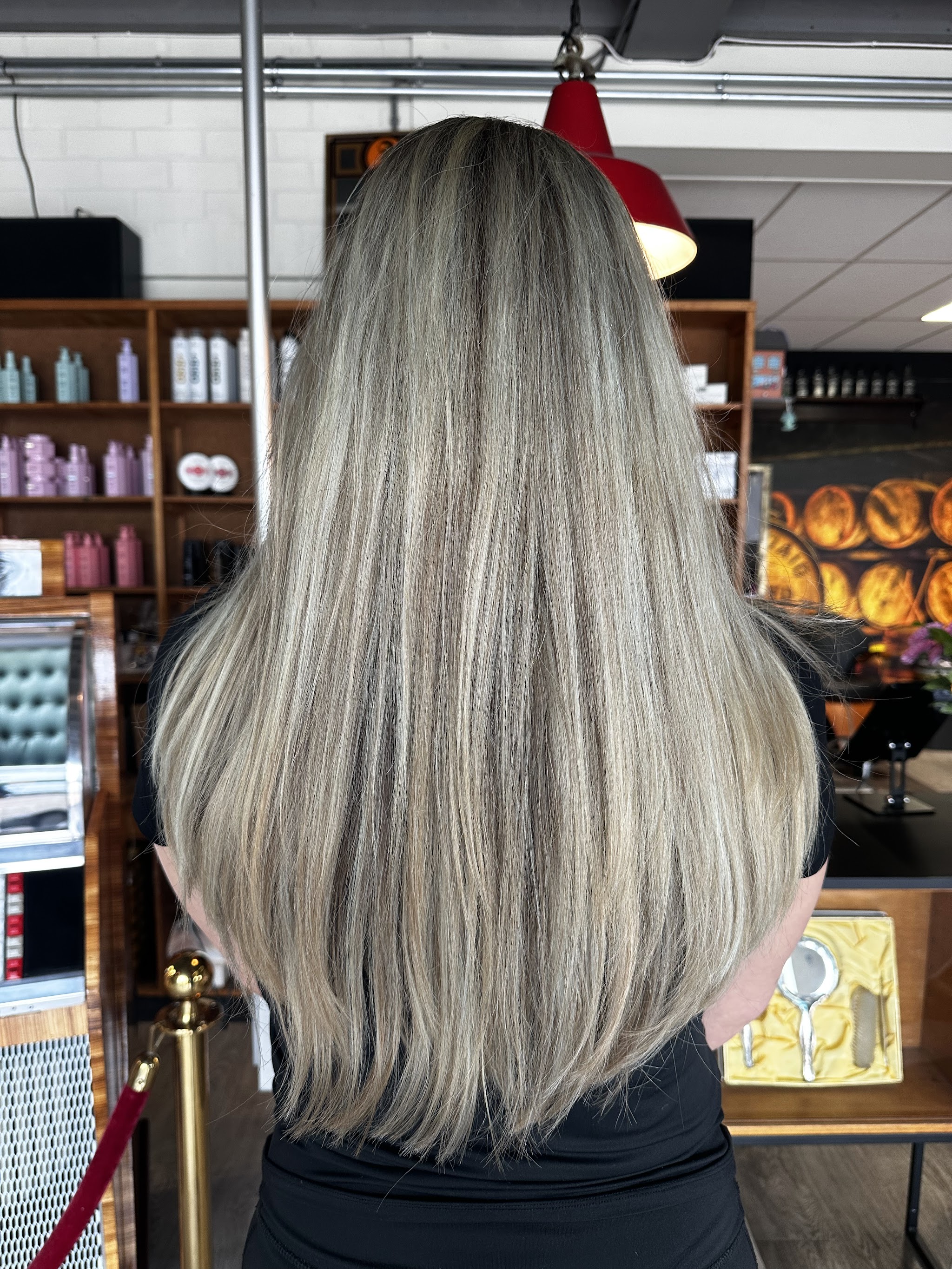 Lang, steil asblond haar, van achteren gezien in de salon